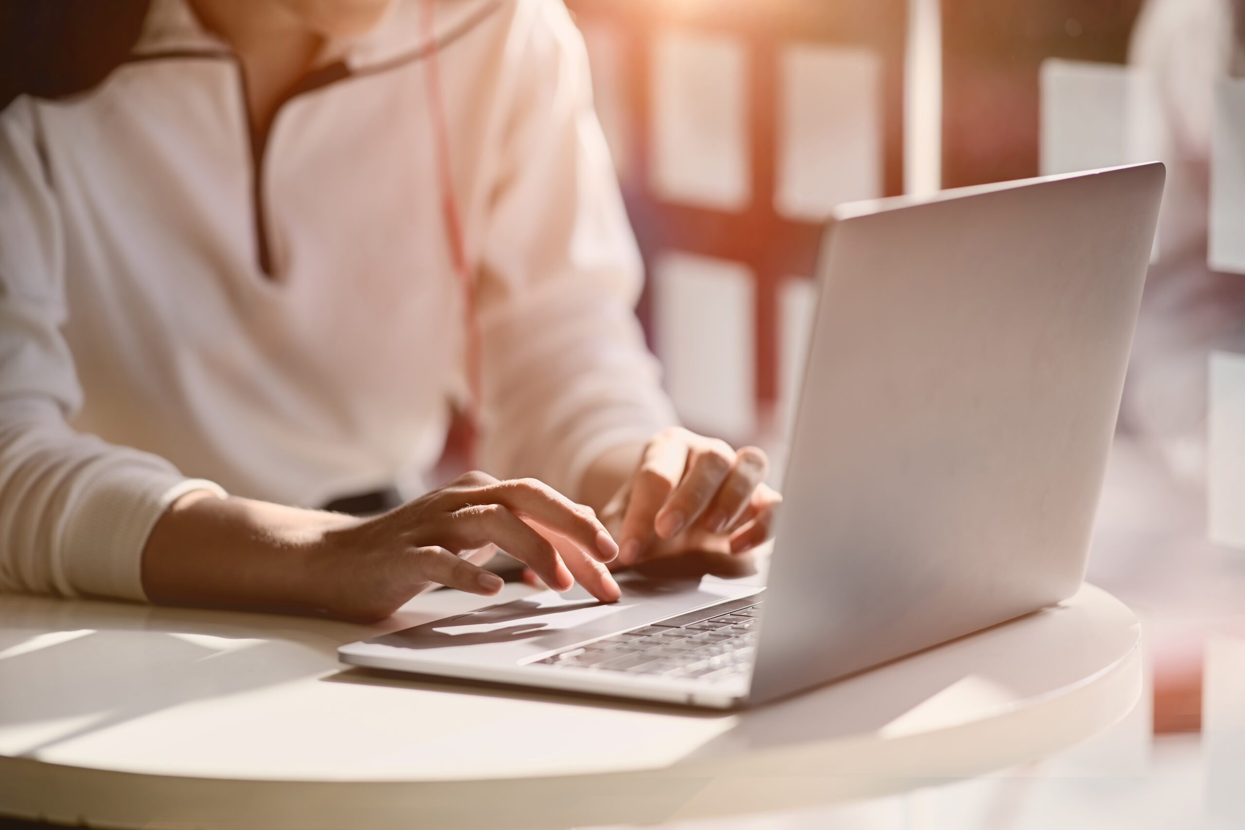 cropped shot of female hand typing on her laptop at home studio workplace