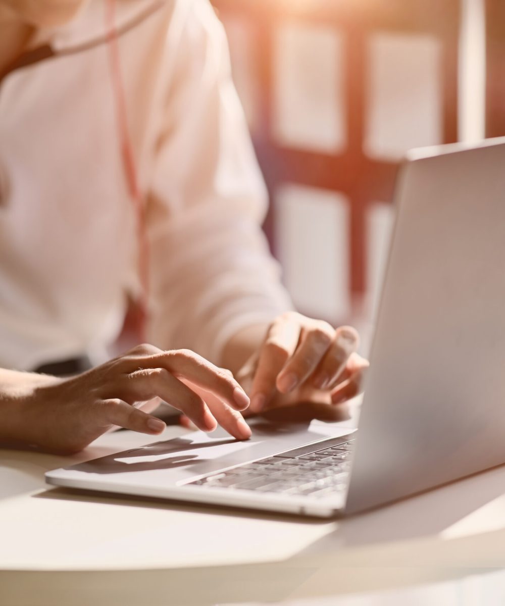 cropped shot of female hand typing on her laptop at home studio workplace